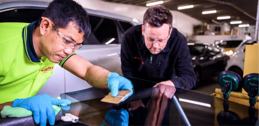 Skilled worker inspecting car glass panel